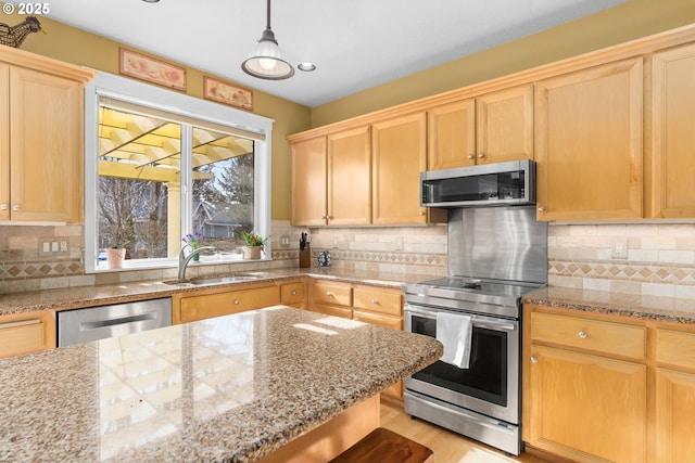 kitchen with tasteful backsplash, sink, stainless steel appliances, and hanging light fixtures