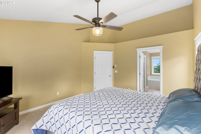 bedroom with ceiling fan, light colored carpet, and ensuite bath