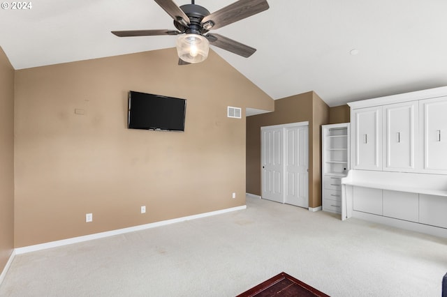 unfurnished bedroom featuring lofted ceiling, light colored carpet, and ceiling fan