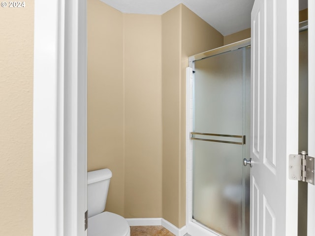 bathroom featuring toilet and walk in shower