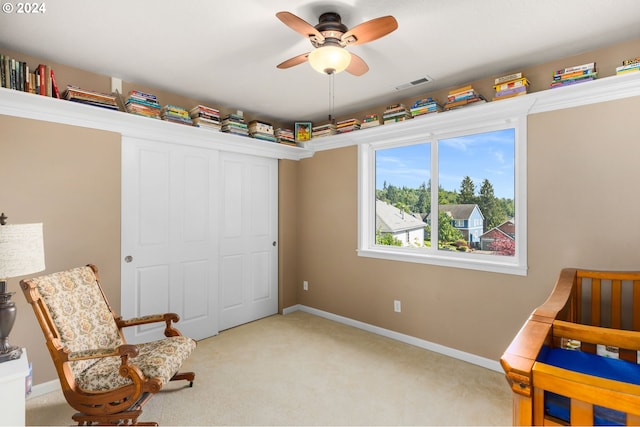 living area with light colored carpet and ceiling fan