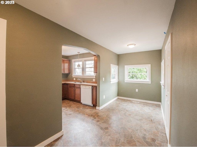 kitchen with white dishwasher, sink, and hanging light fixtures