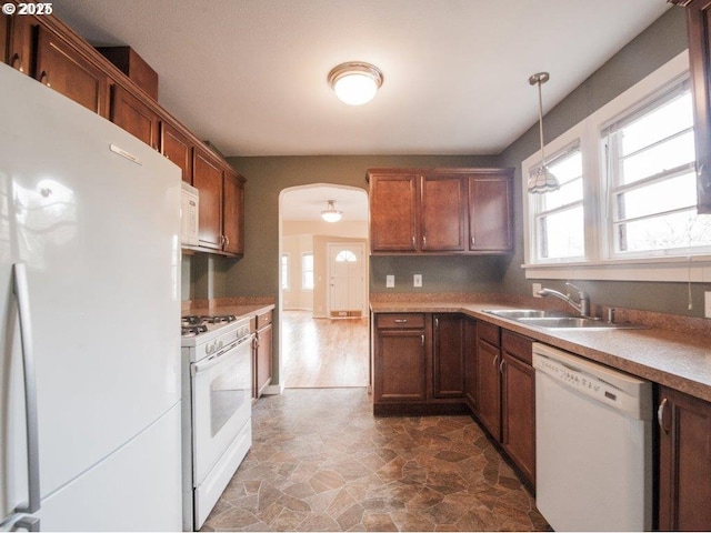 kitchen featuring pendant lighting, sink, and white appliances