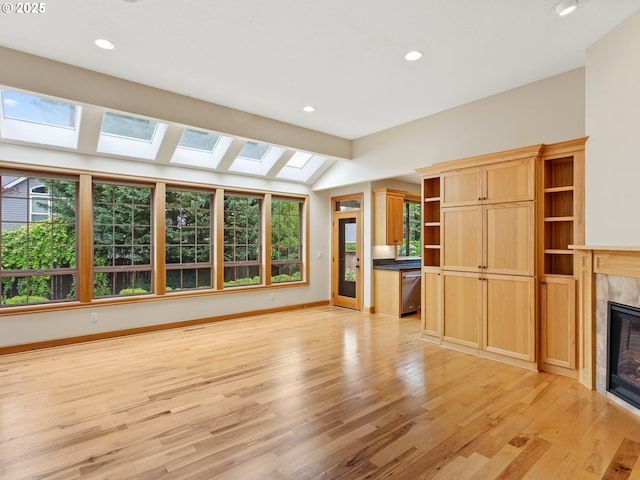 1466 NE 15th Ave, Canby, OR 97013 - unfurnished living room featuring a tile fireplace, a skylight, light wood-style flooring, recessed lighting, and lofted ceiling