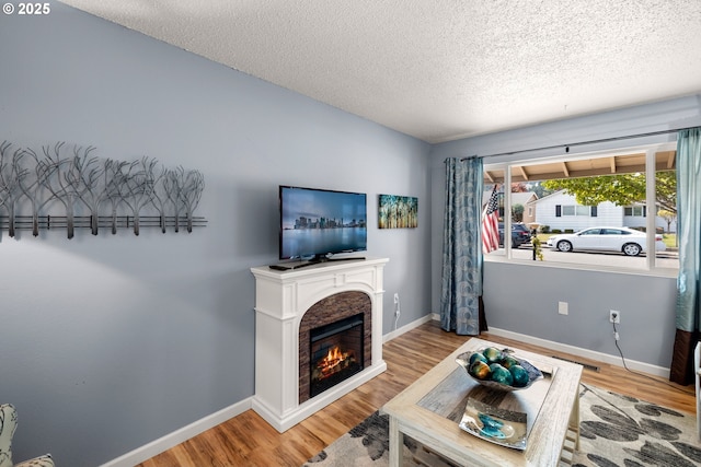 15870 SW Royalty Pkwy, King City, OR 97224 - living room featuring wood finished floors, a textured ceiling, and a glass covered fireplace