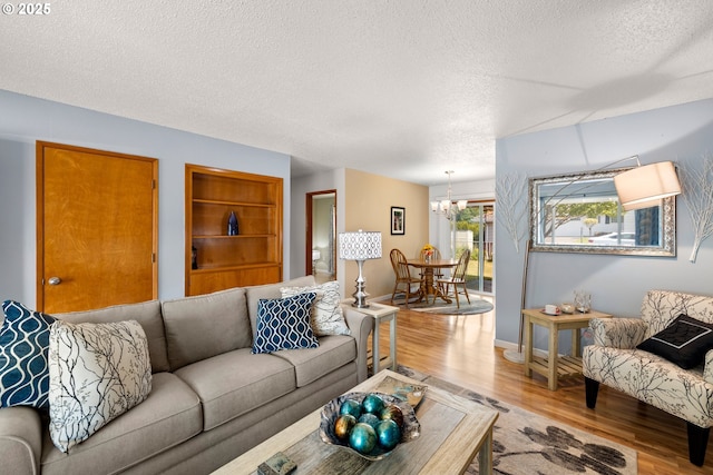 15870 SW Royalty Pkwy, King City, OR 97224 - living area with a textured ceiling, light wood finished floors, a chandelier, and built in shelves