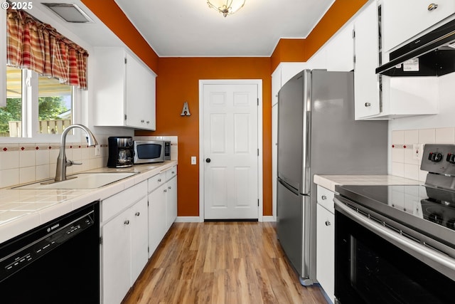 15870 SW Royalty Pkwy, King City, OR 97224 - kitchen with stainless steel appliances, range hood, backsplash, and light wood-style floors