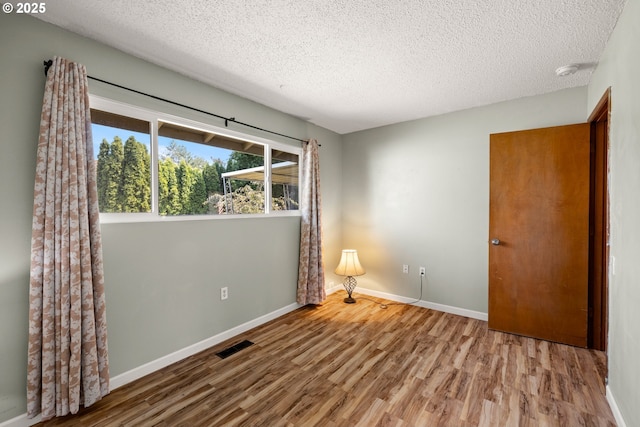 15870 SW Royalty Pkwy, King City, OR 97224 - empty room featuring wood finished floors, a textured ceiling, and a smoke detector