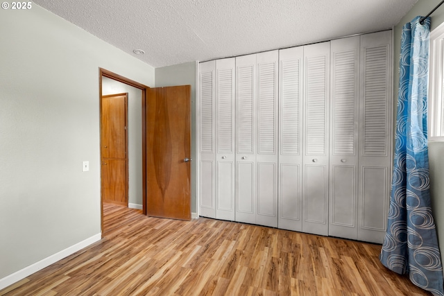 15870 SW Royalty Pkwy, King City, OR 97224 - unfurnished bedroom featuring wood finished floors, a textured ceiling, and a closet