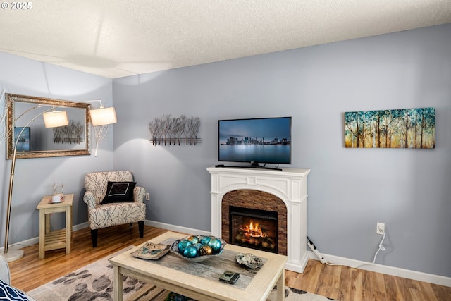 15870 SW Royalty Pkwy, King City, OR 97224 - living room featuring wood finished floors, a lit fireplace, and a textured ceiling