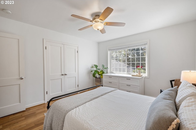 bedroom with light hardwood / wood-style flooring, a closet, and ceiling fan