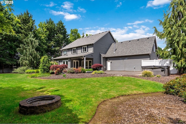 16405 NE 38th St, Vancouver, WA 98682 - back of house featuring a hot tub, a lawn, roof with shingles, and a fire pit