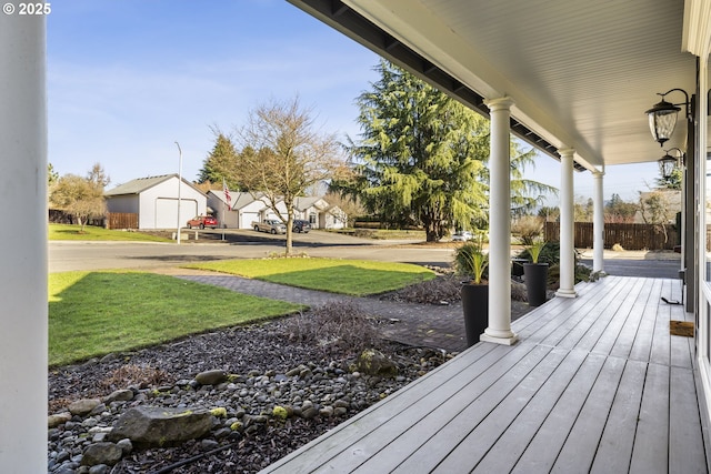 deck with a yard, a porch, and an outbuilding