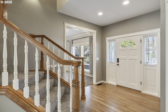 foyer entrance featuring recessed lighting, visible vents, wood finished floors, baseboards, and stairs