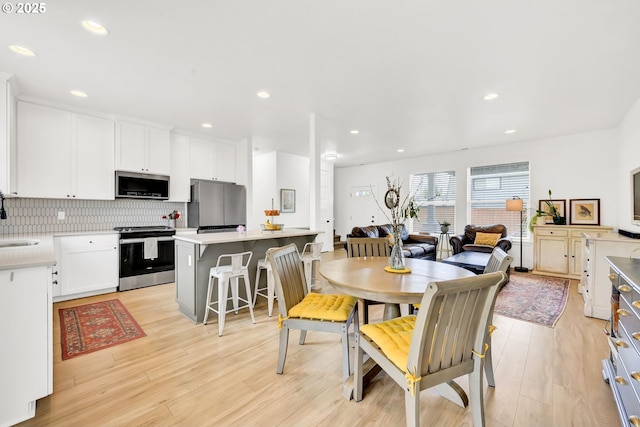 dining space with light wood-type flooring and recessed lighting