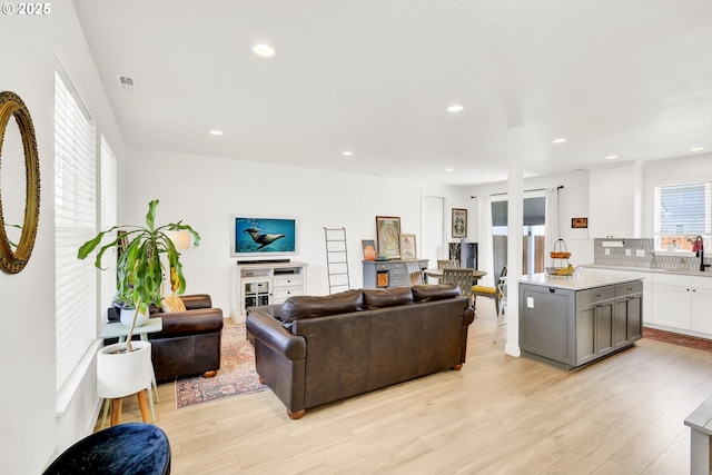 living area with light wood-style flooring and recessed lighting
