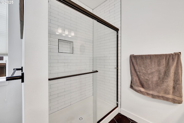 full bathroom featuring a stall shower, baseboards, and tile patterned floors