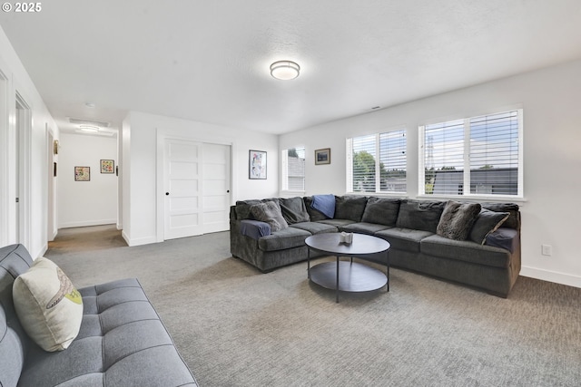 carpeted living area with baseboards