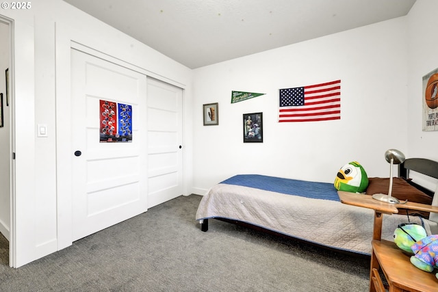 carpeted bedroom with baseboards and a closet