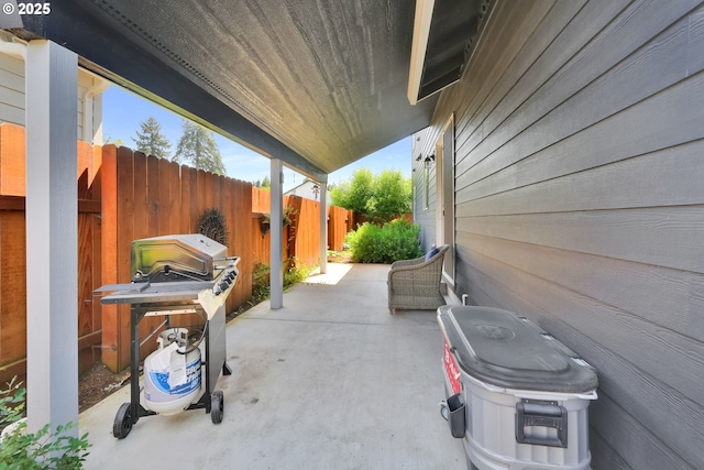 view of patio featuring fence and a grill