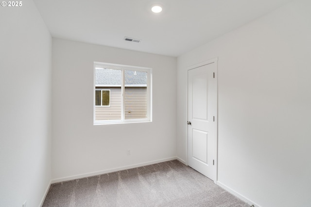 carpeted spare room with baseboards, visible vents, and recessed lighting