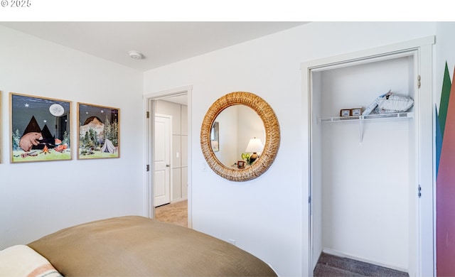 bedroom featuring a closet, light colored carpet, and baseboards