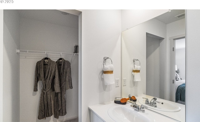 bathroom with visible vents, vanity, and ensuite bath