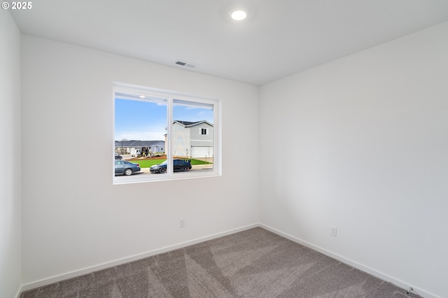 empty room featuring baseboards, visible vents, and carpet