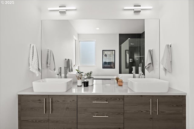 full bath featuring double vanity, a sink, and a shower with shower door