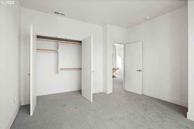 unfurnished bedroom featuring a closet, carpet, visible vents, and baseboards