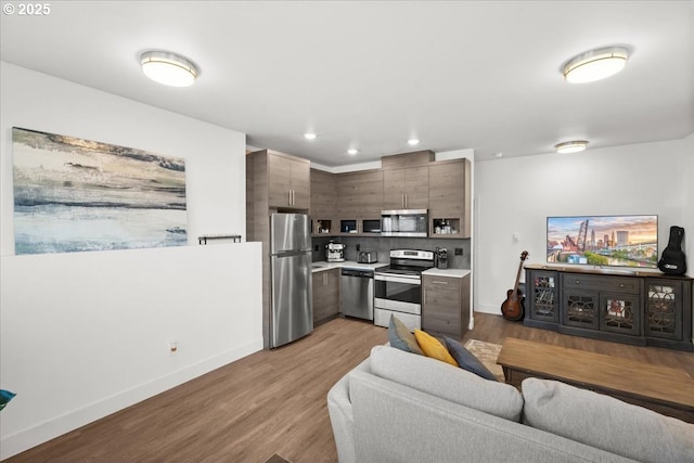 living room with baseboards, wood finished floors, and recessed lighting