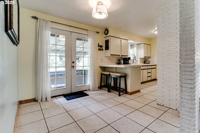 kitchen with sink, tile counters, light tile patterned floors, and electric stove