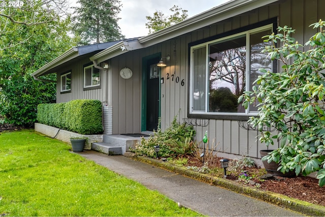 doorway to property with a lawn