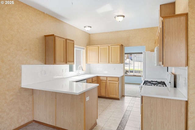 16917 SE Dunhill Loop, Damascus, OR 97089 - kitchen with a peninsula, light brown cabinetry, white microwave, gas stove, and light tile patterned flooring