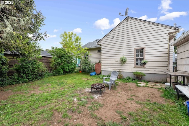 exterior space featuring an outdoor fire pit and fence