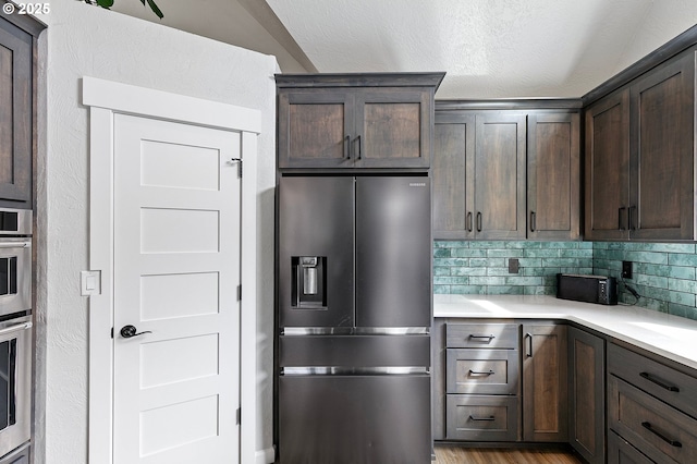 3430 Breezewood Ave, Eugene, OR 97405 - kitchen with high end fridge, light countertops, dark brown cabinetry, tasteful backsplash, and light wood-style flooring