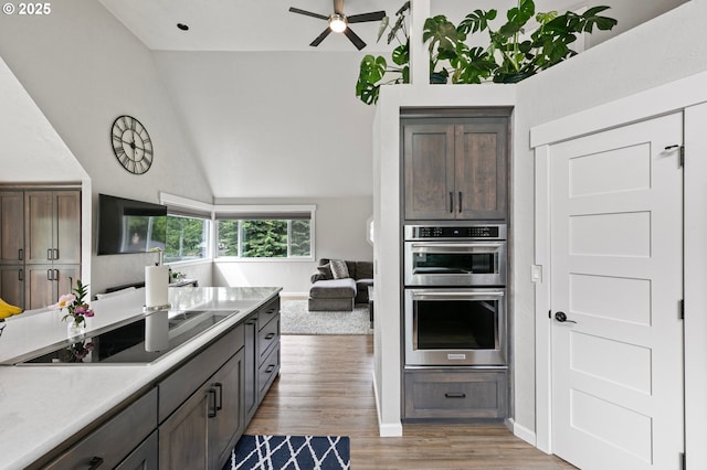 3430 Breezewood Ave, Eugene, OR 97405 - kitchen with black electric cooktop, double oven, vaulted ceiling, light wood finished floors, and ceiling fan