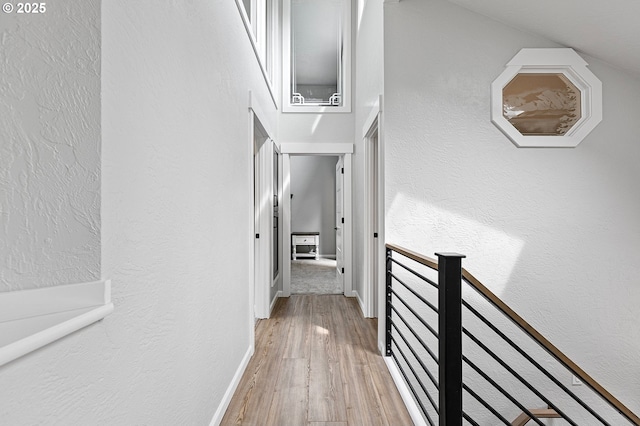 3430 Breezewood Ave, Eugene, OR 97405 - corridor with an upstairs landing, light wood-style flooring, a textured wall, and baseboards