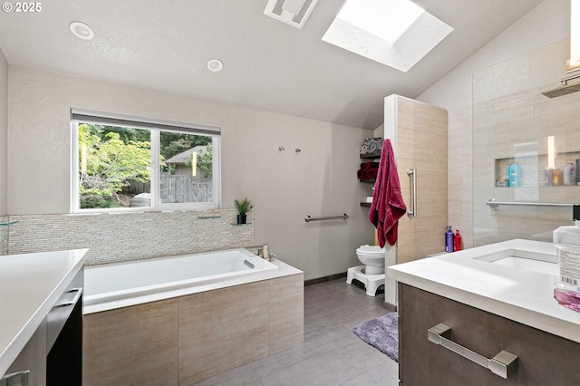 3430 Breezewood Ave, Eugene, OR 97405 - bathroom with vanity, a skylight, a bath, toilet, and vaulted ceiling