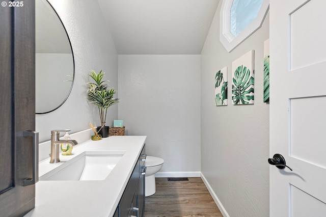 3430 Breezewood Ave, Eugene, OR 97405 - bathroom with toilet, wood finished floors, vanity, baseboards, and lofted ceiling