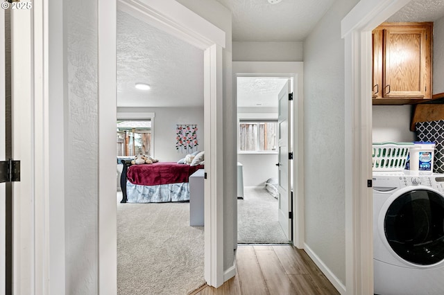3430 Breezewood Ave, Eugene, OR 97405 - laundry area featuring washer / dryer, wood finished floors, a textured ceiling, baseboards, and a textured wall