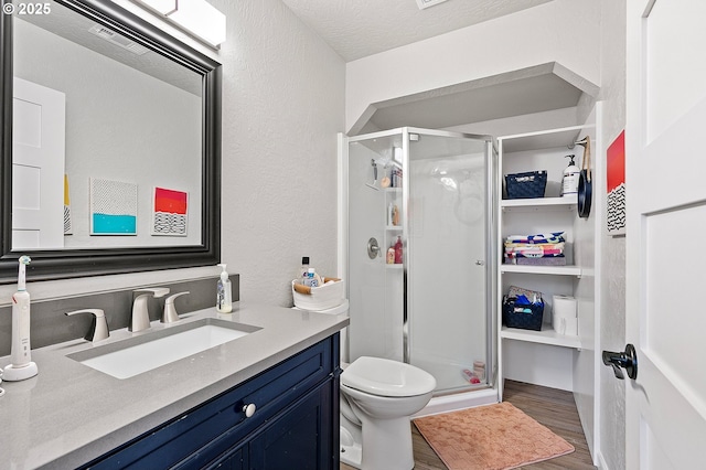 3430 Breezewood Ave, Eugene, OR 97405 - bathroom featuring wood finished floors, a shower stall, vanity, toilet, and a textured ceiling