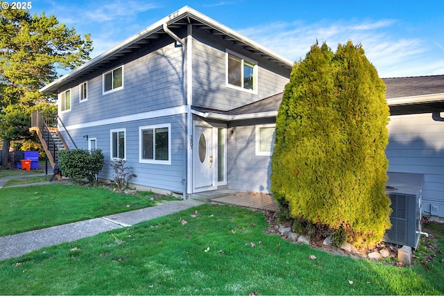 view of front of property featuring a front lawn and central AC unit