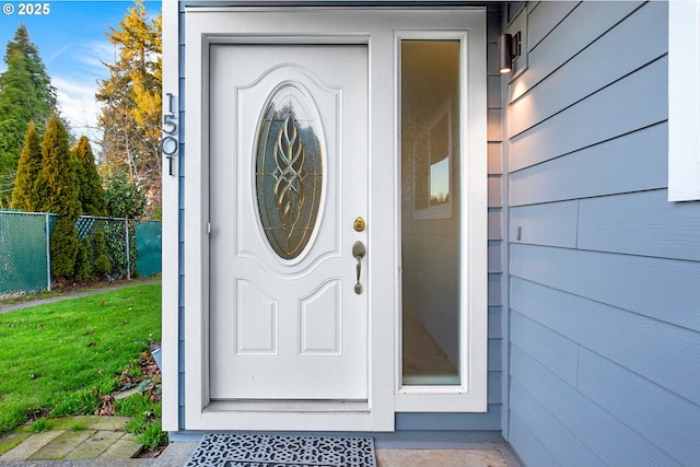 view of exterior entry with a lawn