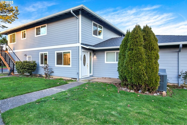 view of front of home with a front yard and cooling unit