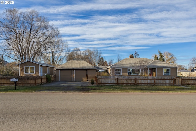 view of front of home with an outbuilding, a fenced front yard, and a detached garage