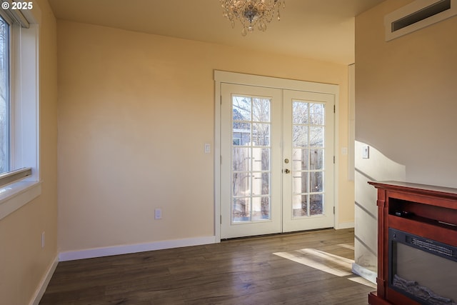 doorway with an inviting chandelier, dark hardwood / wood-style floors, and french doors