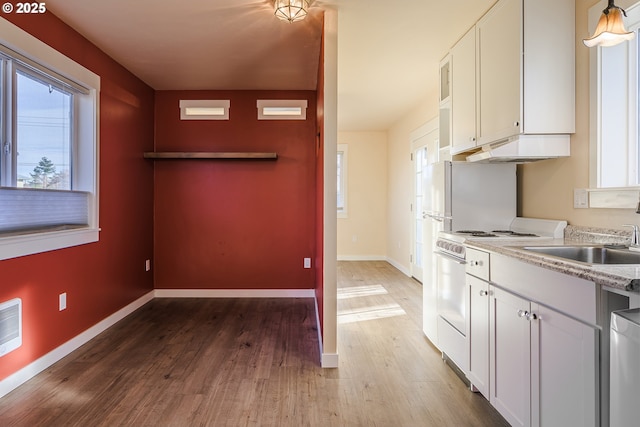 kitchen with dishwasher, white cabinetry, wood-type flooring, sink, and electric stove