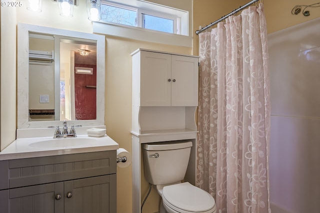 bathroom with vanity, a shower with shower curtain, and toilet