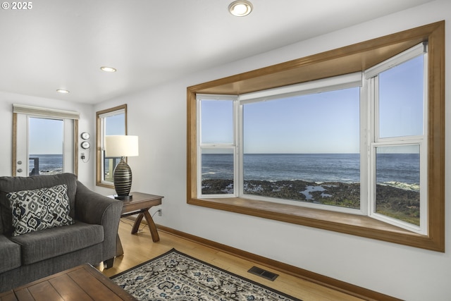 living room featuring a water view and hardwood / wood-style flooring